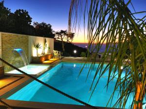特雷斯努拉吉斯Casa Oleandri的游泳池,晚上可欣赏到海景