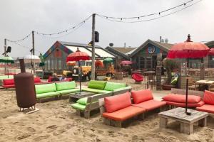 滨海卡特韦克Piet's Beachhouse的休息区配有色彩缤纷的椅子和遮阳伞