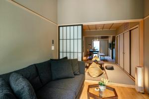 金泽Hanatsume Machiya House的客厅配有沙发和桌子