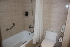 嘉义市嘉义兆品酒店的浴室设有卫生间和带淋浴帘的浴缸。