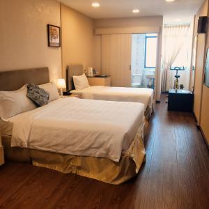 斯里巴加湾市Coconut Bay Lodge - Beribi的酒店客房设有两张床和窗户。