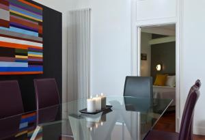 那不勒斯Elegant Apartment at Chiaia by Wonderful Italy的一间设有玻璃桌和绘画的用餐室