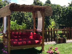 特拉布宗Sky Villa Hisar的庭院里带红色沙发的木制凉棚