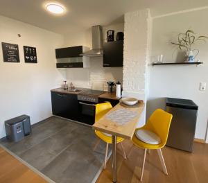 巴特Ferienwohnung "Boddenland"的厨房配有木桌和黄色椅子