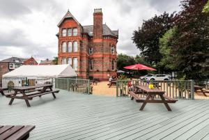 利物浦塞夫顿公园酒店的一座大型砖砌建筑,前面设有野餐桌