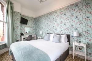 利物浦塞夫顿公园酒店的一间卧室配有一张床和花卉壁纸
