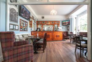 利物浦塞夫顿公园酒店的一间带酒吧和桌子的用餐室