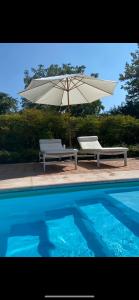 明乔河畔的瓦雷奇奥La Guarnigione的游泳池旁的2张长椅和遮阳伞