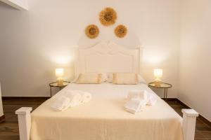 曼塔罗塔Casa da Lota的卧室配有白色的床和2条毛巾
