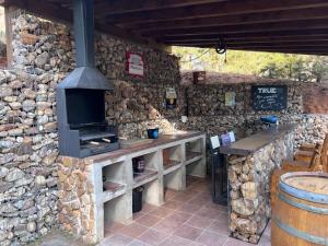 UcedaStone Garden, Casa en plena naturaleza的石头建筑,设有带炉灶的酒吧