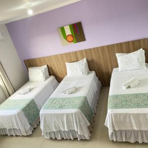 DianópolisHotel Rio Verde的酒店客房,配有两张带白色床单的床