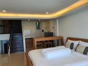 Ban PhalaGrace Seaview บ้านพักส่วนตัว 3 ห้องนอน วิวทะเล หาดพลา的一间卧室配有一张床,厨房配有桌子