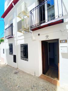 格拉纳达Apartamentos Indalo a los pies del Albaicín的白色的建筑,设有门和阳台