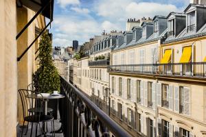 巴黎Pavillon Faubourg Saint-Germain & Spa的阳台配有桌椅和建筑