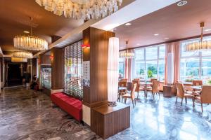 兹林考斯特莱科温泉酒店的用餐室设有桌椅和窗户。