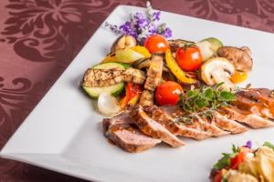 兹林考斯特莱科温泉酒店的肉和蔬菜的白盘食物