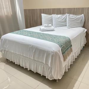 DianópolisHotel Rio Verde的一张配有白色床单和毛巾的大床