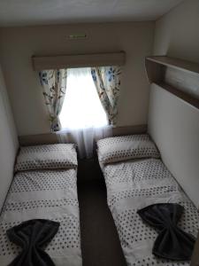 Great BillingLovely Static 8 Bed Caravanat at Billing Aquadrome的小型客房 - 带2张床和窗户