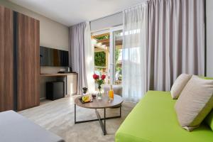 乌马格Residence Garden Istra Plava Laguna的客厅配有绿色沙发和桌子