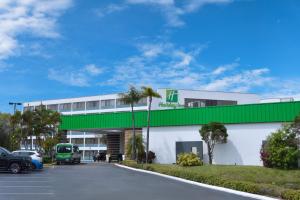 克利尔沃特Holiday Inn St. Petersburg N - Clearwater, an IHG Hotel的一座带绿色屋顶和停车场的建筑