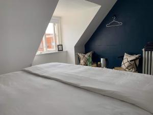 根措夫特Room in a Danish cottage with garden view, 10 min to CPH的一间卧室配有一张白色大床和蓝色的墙壁