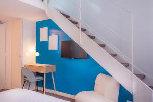 巴黎Makom Pereire的客房设有床、书桌和楼梯。