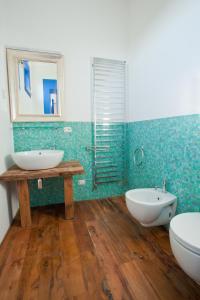 蒙德拉戈内Hotel & Resort Lunatenuta的浴室设有2个水槽、镜子和浴缸。