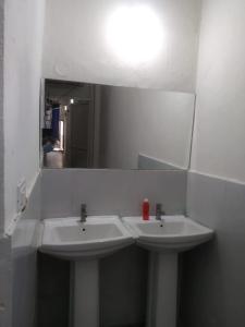 海得拉巴Abuzz OxfordCaps, Genome Valley Hyderabad的浴室设有2个白色水槽和镜子