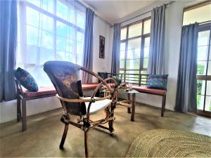 阿鲁沙Holiday cottage by the river, Arusha的客房设有椅子、桌子和窗户。
