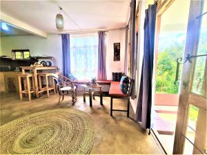 阿鲁沙Holiday cottage by the river, Arusha的客厅配有桌椅和窗户。