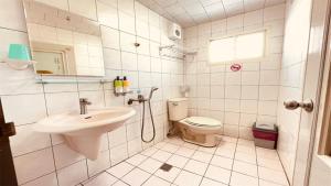 小琉球岛大峰民宿的白色的浴室设有水槽和卫生间。