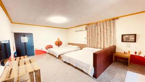 小琉球岛大峰民宿的一间卧室配有两张床和一张桌子