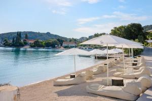 科尔丘拉塔拉旅馆酒店的海滩上的一组白色椅子和遮阳伞