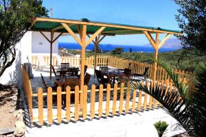 DhrapaniásVillage Villa Marika - Mimis Drapanias的木亭子,配有桌子和木栅栏