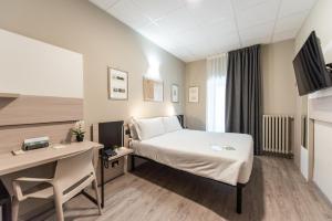 都灵Green Class Hotel Gran Torino的配有一张床和一张书桌的酒店客房
