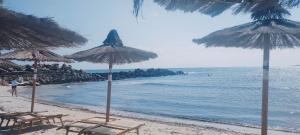 圣维托诺曼Casa vacanza的海滩上设有椅子和遮阳伞,还有大海