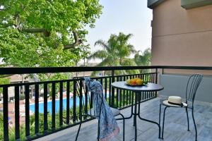 卡塔尼亚Amaranda B&B的一个带桌椅的阳台和一个游泳池