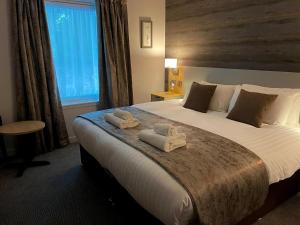斯佩河畔格兰敦克瑞拉克莱格林恩酒店的一间卧室配有一张大床和毛巾