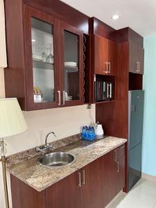 姆巴巴内Open House Hotel的厨房配有水槽、木制橱柜和冰箱。