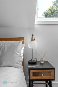 普里茅斯2 Bed- The Penthouse By Pureserviced的一张带桌子的床,上面有台灯