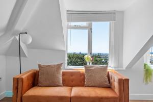 普里茅斯2 Bed- The Penthouse By Pureserviced的客厅里设有橙色沙发,设有窗户