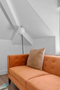 普里茅斯2 Bed- The Penthouse By Pureserviced的客厅配有橙色沙发,设有吊扇