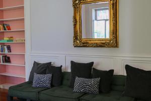 波尔图Rosalma Hostel的客厅配有绿色沙发和镜子