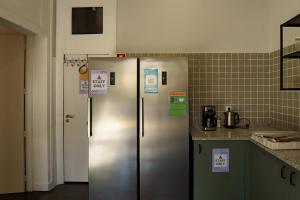 波尔图Rosalma Hostel的厨房配有2台带标志的不锈钢冰箱
