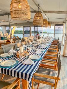 焦济尼Shayamanzi Houseboats的船上一张长桌子,上面有椅子和盘子