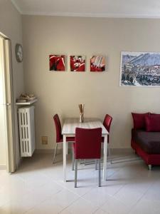 伊夫雷亚Apartment "Borgo Olivetti"的一间设有白色桌子和红色椅子的用餐室