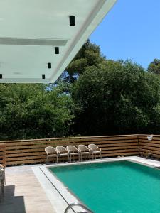 格勒姆Adria Hotel的一座带椅子的游泳池,毗邻木栅栏