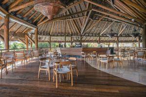 普拉亚多Iberostar Selection Praia do Forte的一间带桌椅和大型天花板的餐厅