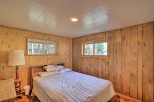 克拉马斯福尔斯Cozy Klamath Falls Home Near Fishing and Parks!的一间带木镶板的卧室和一张床铺
