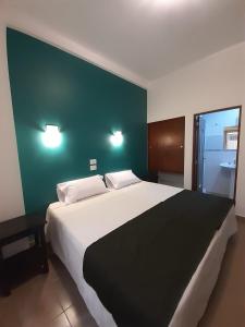 圣萨尔瓦多德朱Parque Hotel的一间卧室设有一张大床和绿色的墙壁